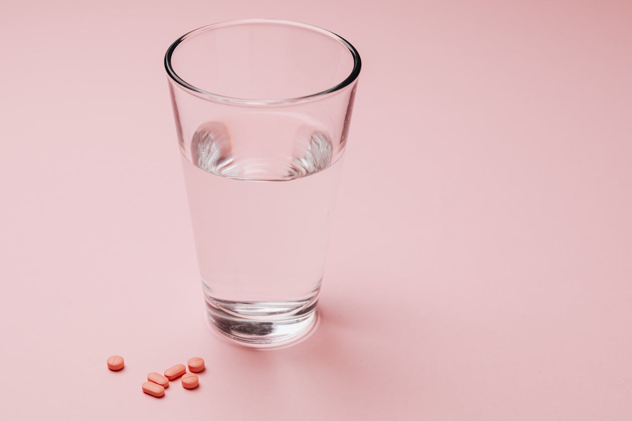 glass of water beside supplement capsules ready for a morning routine