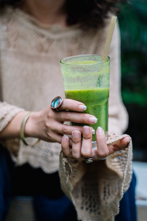 woman holding a green moringa drink for daily wellness