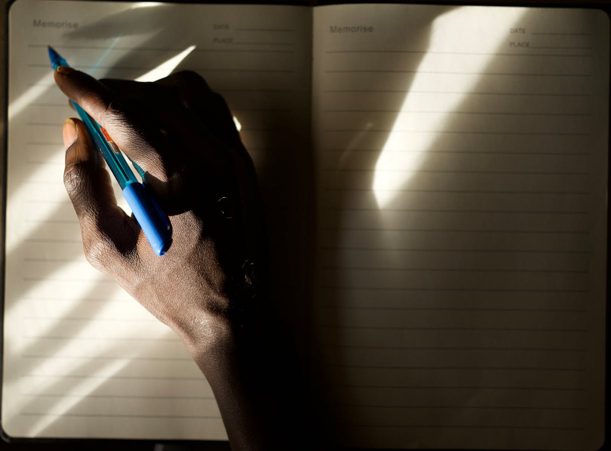 Person writing notes in lined notebook starting a daily two-minute habit