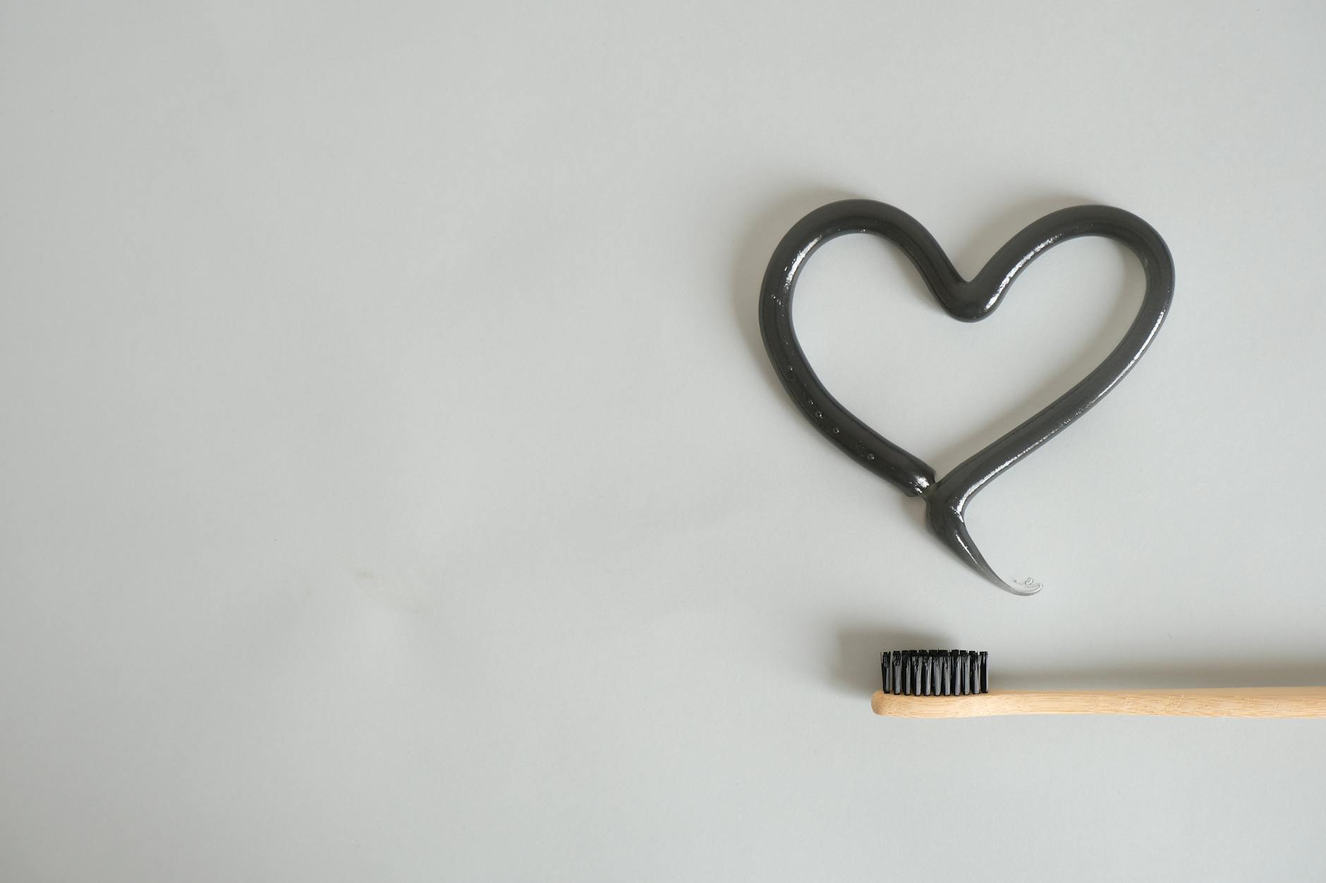 Charcoal toothpaste with bamboo toothbrush on a clean background