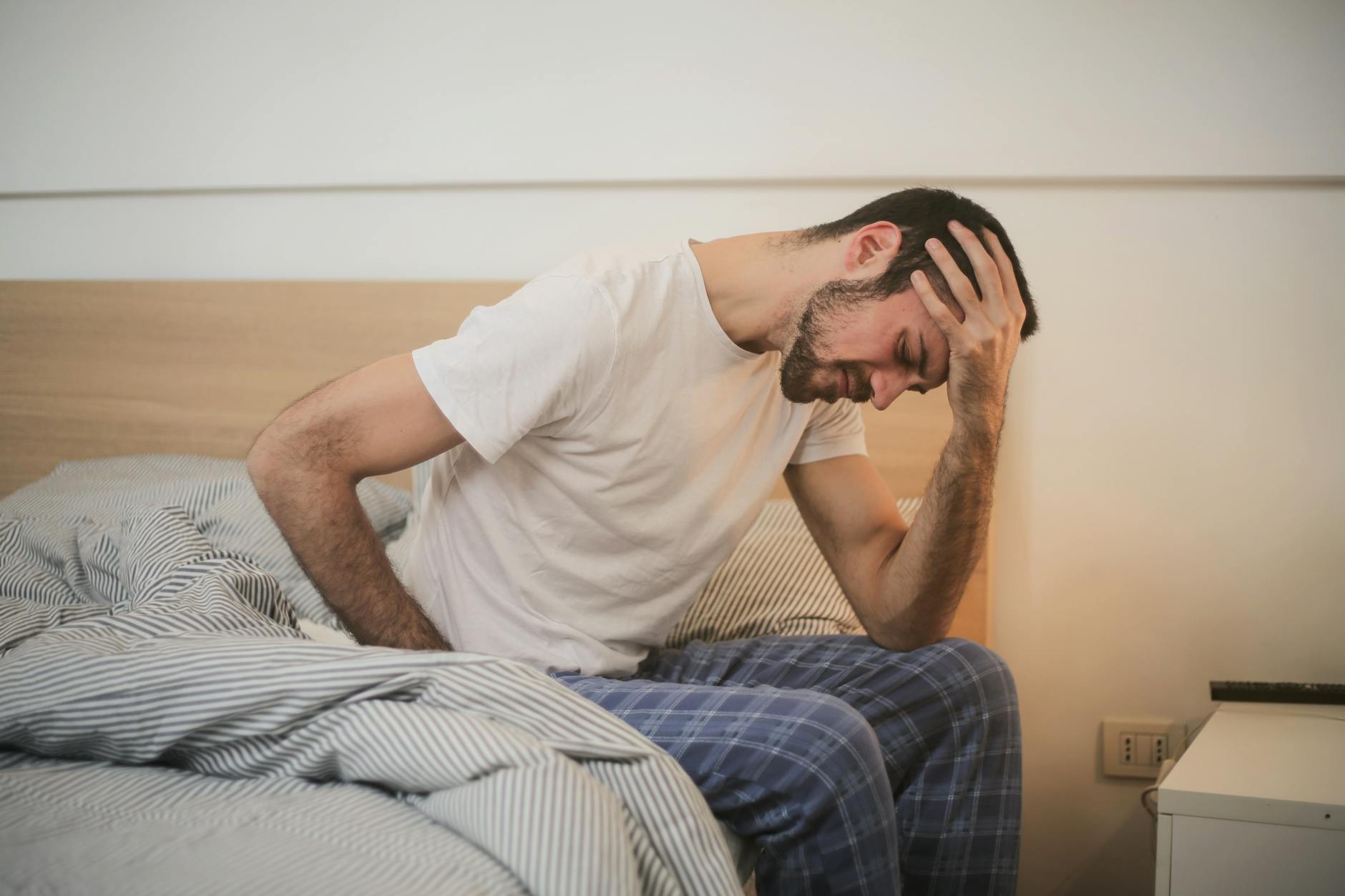 Tired woman sitting on a sofa during a heavy metal detox protocol experiencing Herxheimer reaction symptoms
