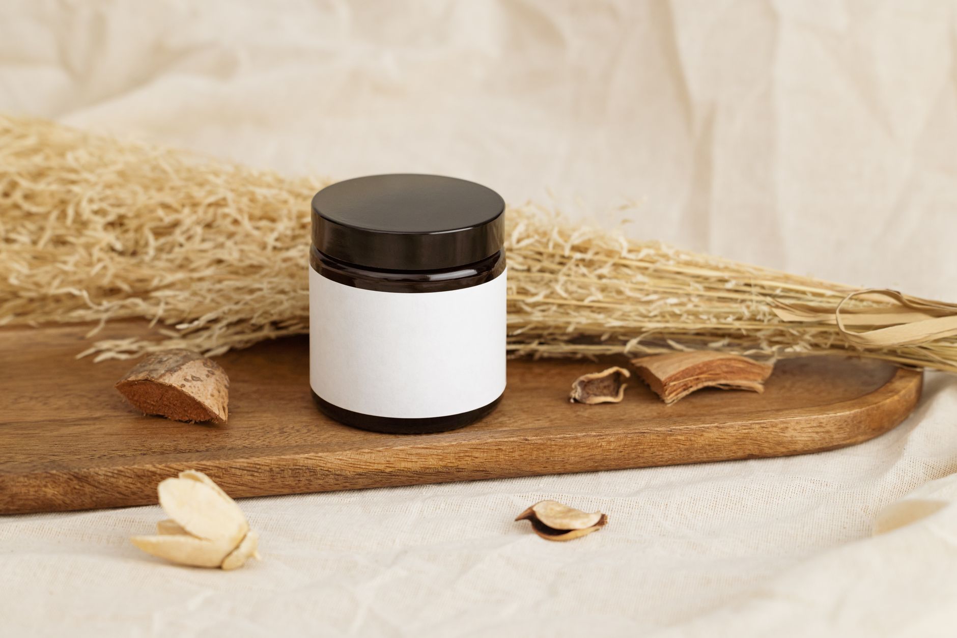 Natural cosmetic jar with blank label on a rustic wooden tray, ideal for storing homemade toothpaste