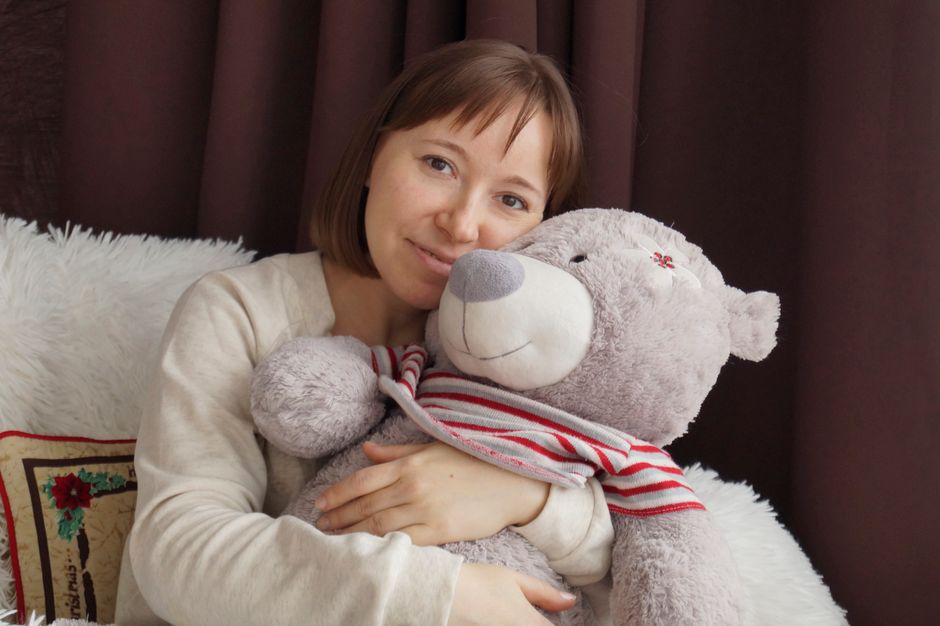 Adult holding a plush warmie comfort object, a heatable stuffed animal for adult anxiety relief